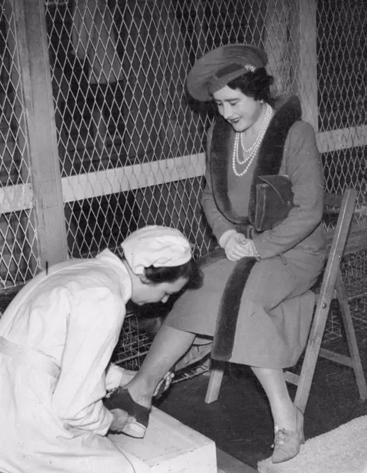 Royal visit to Ministry of supply factories. The Queen has special shoes fitted before going. Into the danger area, during a visit to a Ministry of supply factory, with the King. December 04, 1941.  (Photo by Sports & General Press Agency, Limited).
