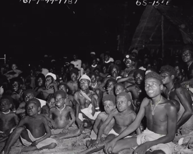 ***** natives watching their first movie show, which was ***** and wonder to them, as may be seen from ***** in their eyes. The animal cartoon appealed to *****. May 08, 1944.