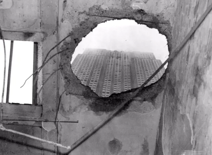Where Part Of Plane Crashed -- This odd view was taken through hole in roof of Penthouse on 33rd street, New York, July 28, across the street from the Empire State Building -- A roof through which part of crashed plane fell and set Penthouse afire. July 28, 1945. (Photo by Associated Press Photo).