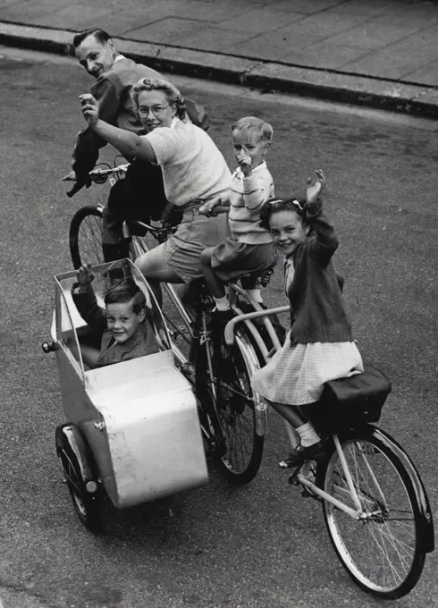A "Carriage" For FiveMr. Eric Jewell of Finchley, London, was fed up with queueing for buses with tired children, so with his wife, he went back to his hobby of cycling. He built a sidecar and added to his tandem - bicycle. But this was not enough to hold all the family so half a bicycle was tacked on behind and an extra saddle and a pair of hadlebars placed behind mother - now he has a quinticycle made for five and the family are all happy as they travel around together. August 08, 1950. (Photo by Paul Popper Ltd.).