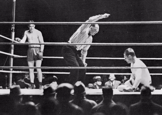 Scott Knocked Out in Amazing Scenes - Young Stribling standing in the neutral corner while Phil Scott takes a count of nine. May 26, 1947. (Photo by Central News).