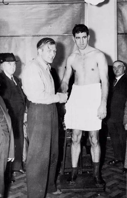 Strickland And Neusel Weigh In For Big Fight -- Walter Neusel (left) and Maurice Strickland on the scales at the weigh-in for the big fight.Walter Neusel, Germany Heavyweight, is fighting Maurice Strickland, New Zealand, at Wembley Stadium here tonight in an attempt to make a come-back after his recent defeat by Tommy Farr. In a visit to the United States a month ago Strickland had considerable success. October 19, 1937. (Photo by Associated Press Photo).