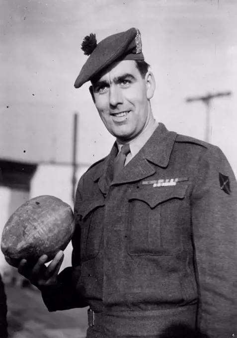 Korea V.C. Home -- Private Bill Speakman with the coconut he brought home from Korea for his kid brother Bert.Private William Speakman, who was awarded the Victoria Cross in Korea, was greeted by the Mayor of his home town Altrincham, Cheshire, when he arrived from the Far East at Lyneham Airport to-day. January 29, 1952. (Photo by Daily Mail Contract Picture).