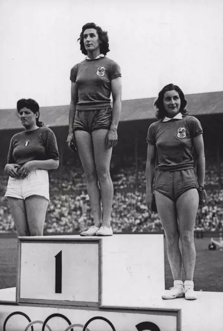 Olympic Games 1948 - Women Discussion - ***** M. Ostermeyer of France ***** gold winner of the Women's ***** even with 137ft 6½ ***** she stands between G.E.C. - ***** Italy who was second (left) ***** of France, third. July 31, 1948.