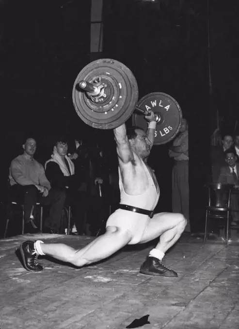 Olympic Weight - Lifter : Seen here snatching 250 pounds to win the British Middleweight championship in London on Saturday (June 21st), H. Halliday, of Kearsley, Lancashire, has been chosen to represent Britain as a Lightweight in the Weight-lifting contests at the Olympic Games in Helsinki. June 24, 1952. (Photo by Reuterphoto).