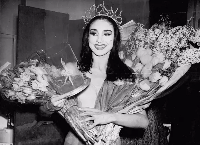 Partner For Don Quixote - 12 Encores For British Star -- Margot Fonteyn returning with an armful of flowers and a ballerina doll, to her dressing room at the Royal Opera House, Covent Garden, London. She danced as Dulcinea in the first performances of the ballet "Don Quixote". Margot too 12 curtain calls. For three of them the stars were joined by Ninette de Valois, "Don Quixote" is her first ballet for seven years. February 21, 1950. (Photo by Paul Popper Ltd.)