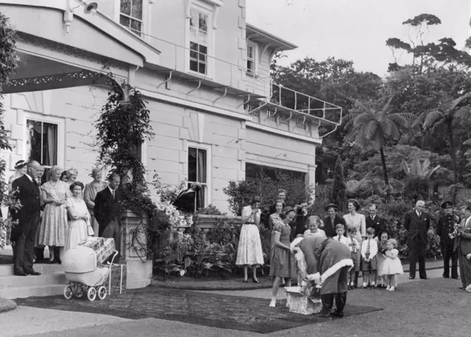 Santa Claus at Government House on Xmas Day. Among his presents were gifts for the Queen, the Duke, Prince Charles and Princess Anne. He came on a sleigh drawn by six ponies. The Queen and the Duke are on the left with the Governor General and Lady Norrie. January 06, 1954. (Photo by The N.Z. Herald).