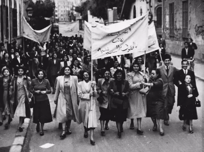 Egyptian Suffragettes:The procession En Route from the University to the parliament building. Banner at front reads "women's groups demand political rights for women."Police closed the doors of parliament building, Cairo, Feb. 19, when an estimated 500 women demonstrators attempted to enter the building to claim political rights after a meeting of the Egyptian feminist party at the Ewart Memorial Hall of the American University. March 7, 1951. (Photo by Associated Press Photo).