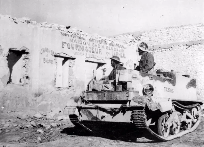 Scars Of Mareth Line Fighting -- In a Desert-Worn tank, British Tommies who played roles in the Victory of the Mareth line look over damage done by the fighting to one of the few shops at Mereth. April 14, 1943. (Photo by Associated Press Photo). 