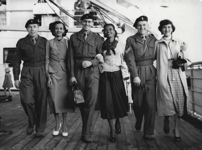 Home From Guiana With Their Brides -- Three if the married couples arriving at Southampton aboard the troopship Dilwara today (Tuesday) are these men of the 1st Battalion the Argyll and Sutherland Highlanders with their brides from British Guiana.Left to right are: Corporal Reg Shepherd, of Bognor with his wife Marger, 20; Cfsm Cliff Perrett, of Salisbury, with his wife Ivy, 25; and Corporal Ken Campion, of Canterbury, with his wife Magiby, 23. November 02, 1954. (Photo by Reuterphoto).