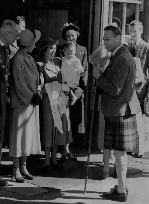 Bonnie Prince Charles Crosses The Border -- Prince Charles makes a grab for his grandfather's stick as his Nurse, Helen Lightbody carries him from Ballater Station. At left is Princess Elizabeth, next to canon W.E. Adams (extreme left) provost of Ballater. (Queen Elizabeth is hidden by the King, others unidentified). Young Prince Charles made a raid across the border between England and Scotland August 6, and captured the hearts of the highlanders who saw him for the first time since his birth nearly a year ago. With his mother, Princess Elizabeth, aunt Princess Margaret and grandparents, King George and Queen Elizabeth, her went by train to Ballater, and from there to Balmoral Castle, where the family will spend a holiday. August 15, 1949. (Photo by Associated Press Photo).