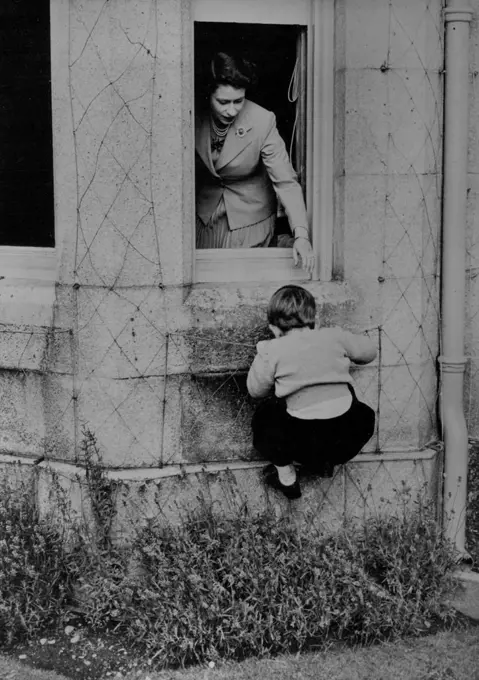Mountaineering At Balmoral :H.R.H. Prince Charles is seen in his attempt, which he successfully accomplished, to climb in through one of the windows of Balmoral Castle. H.M. The Queen stands at the open window ready to give her small son a helping hand, should it be required. May 1, 1953. (Photo by Fox Photos).
