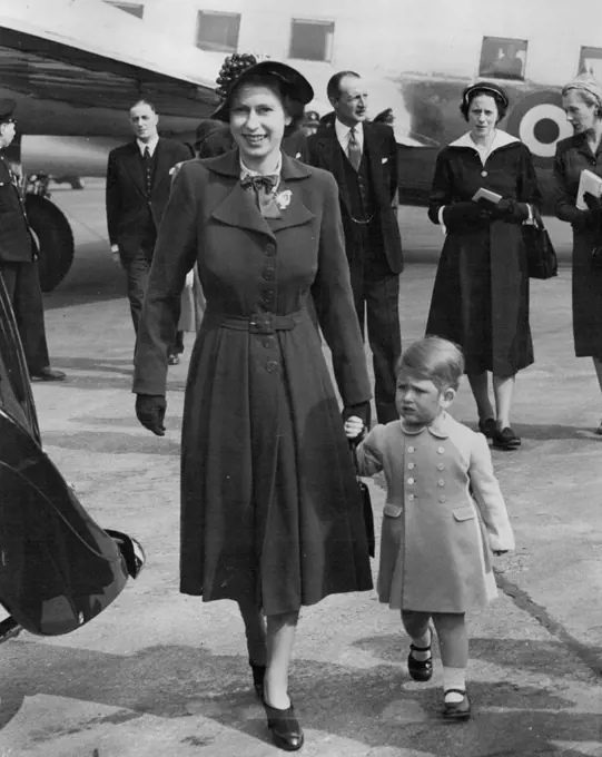 Prince Charles Welcome Home For Mother :Prince Charles holding the hand of his mother Princess Elizabeth, as they walks to the Royal car at London Airport to-day (Tuesday) when the Princess returned home after her visit to home with the Duke of Edinburgh.The Prince was there when the Viking aircraft of the King's Flight landed, and he entered the aircraft to greet his mother. April 24, 1951. (Photo by Reuterphoto).