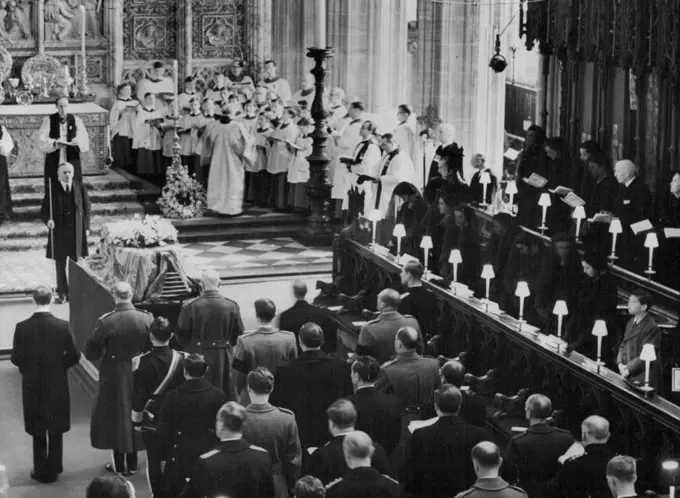 Royal Mourners' Homage To Queen Mary In St. George's Chapel -- Royal Mourners at the funeral service in St. George's Chapel. In the front stall on right are - left to right - the Queen; Queen Elizabeth the Queen Mother; Princess Margaret; the Princes Royal; the Duchess of Gloucester; the Duchess of Kent; her daughter, Princess Alexandra; and the Duchess's younger son, Prince Michael. Standing immediately behind the coffin in the picture are - left to right - the Duke of Kent; the Duke of Gloucester; the Earl of Athlone (Queen Mary's brother), the Duke of Windsor; and the Duke of Edinburgh (extreme right). Behind them are left to right King Hussein of Jordan; King Baudouin of the Belgians; and Crown Prince Olaf of Norway. March 31, 1953.