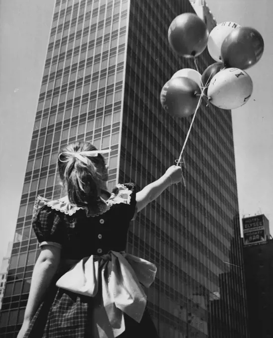 Variations On A Theme - A front view of the building taken from streetlevel at a slight angle contains the added attraction of a little girl holding her balloons as she gazes upward. July 8, 1953. (Photo by United Press).