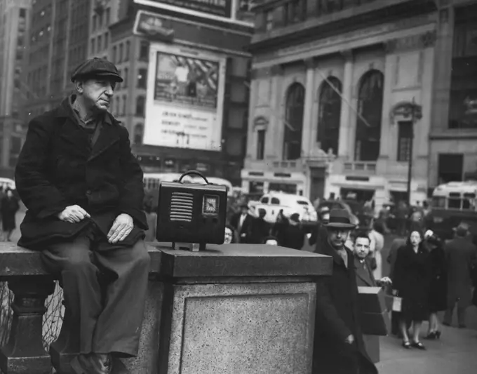 Fifth Avenue Interlude -- Fifth Avenue, the street of fashion and swank in this city, was a street with music today as Otto Feinberg, a longshoreman, paused to listen to this radio as he sat on the terrace wall in front of the New York Public Library on the corner of 42nd Street. Otto, while waiting for the time of his night assignment to roll around, sat in the sun, amusing himself and passers-by.No one thinks it strange that wharfie Otto Feinberg sits on a wall in Fifth Ave., street of swank and fashion to listen to his radio. January 29, 1947. (Photo by Wide World Photo).