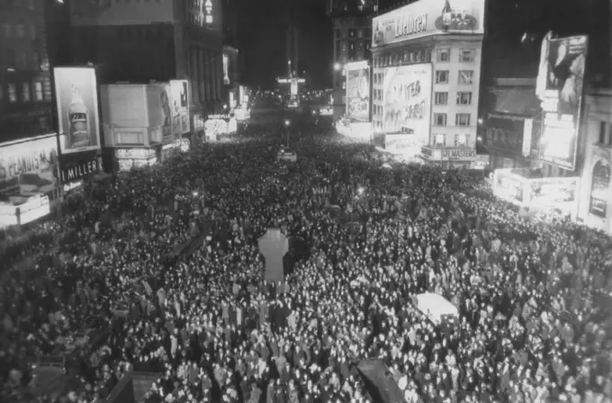 New York Greets New Year - This photo of jam-packed Times Square was made at exactly midnight as New Yorkers gathered to greet the New Year. The view was made from Broadway and 47th streets, looking south. January 01, 1945. (Photo by AP Wirephoto).