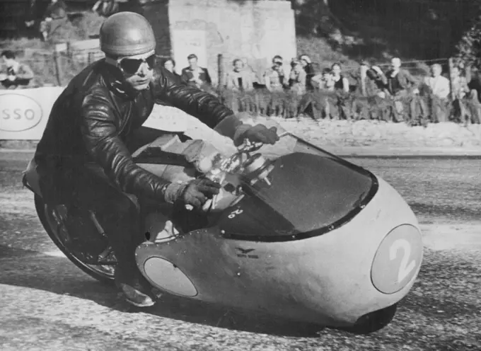 Italian Challenge in T.T. RacesDuillo Acostini, a member of the Italian Guzzi team, at speed on a Junior 350 ***** Guzzi during practice on the T.T. course on the Isle of Man in readlness for next week's races. June 3, 1955. (Photo by Central Press Photos).