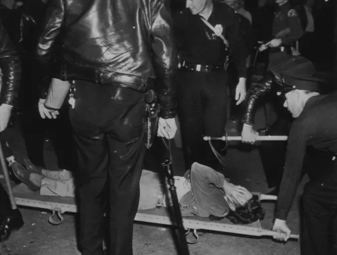 Picket Faints During Movie Strike -- The Excitement at Warner Bros. studio early today, when pickets and Non-strikers fought another battle at the studio gate, proved too much for this woman picket. She fell over in a faint and was taken inside the studio for first aid. October 8, 1945. (Photo by AP Wirephoto).