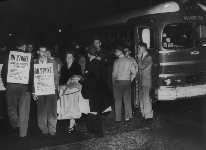 Picket Bus Terminal -- As A  picket line (left) formed early this morning at the Greyhound Bus Terminal here, a bus (right), coming into Washington from the North, discharges its passengers at the curb. Efforts to avert a walkout failed just before the midnight deadline. November 1, 1945. (Photo by AP Wirephoto).