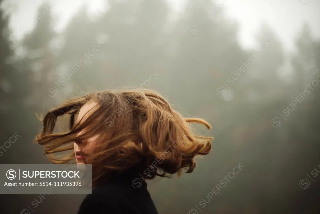 woman standing by forest in foggy weather