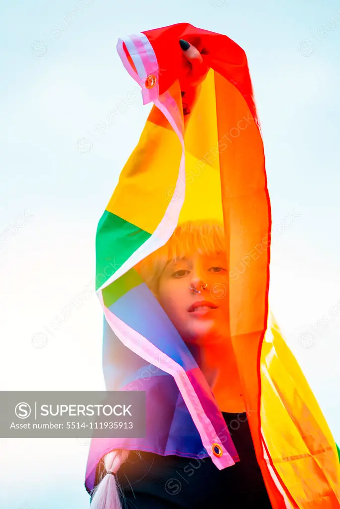 Lesbian woman with the flag of pride in sportswear at gay parade