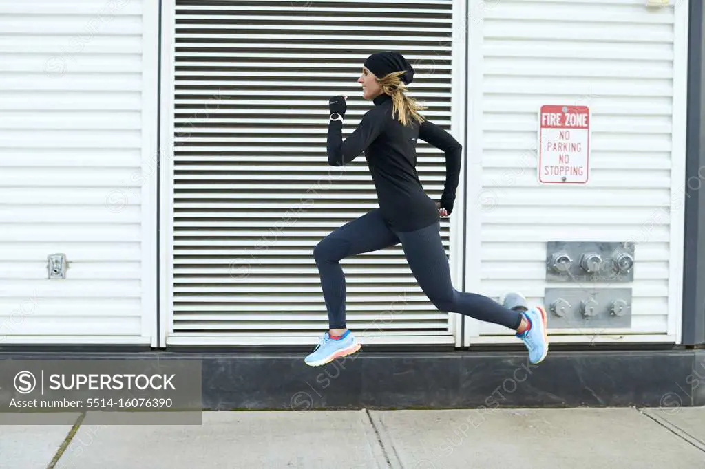 A woman running and jumping in the city.
