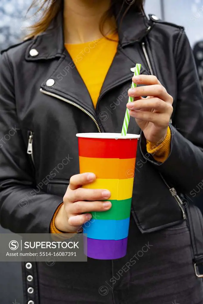 Woman holding a rainbow pride cup