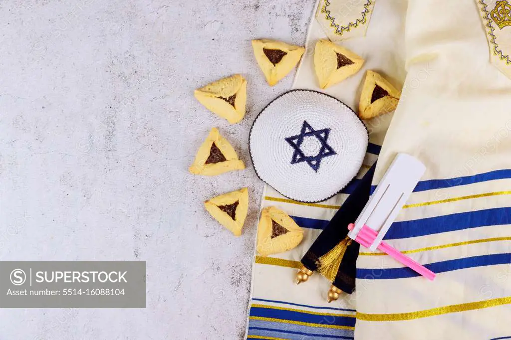 Traditional jewish carnival holiday Purim celebration and hamantaschen cookies, noisemaker and mask, holy book, talit, kippa