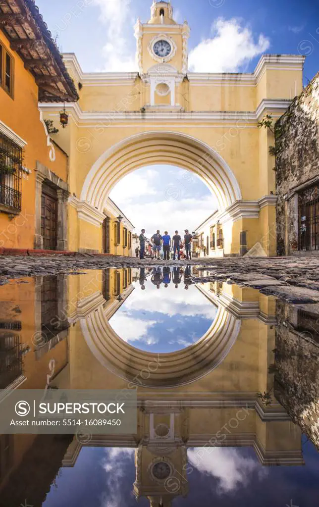 Tourists stand under the Santa Catalina arch in Antigua, Guatemala