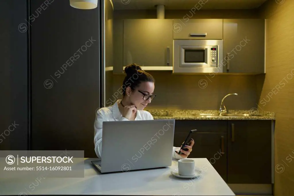 Young woman working with laptop in evening