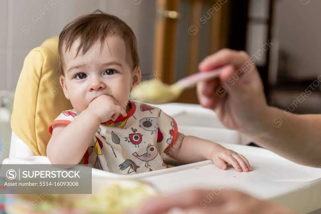 Girl child eating some baby food for lunch.