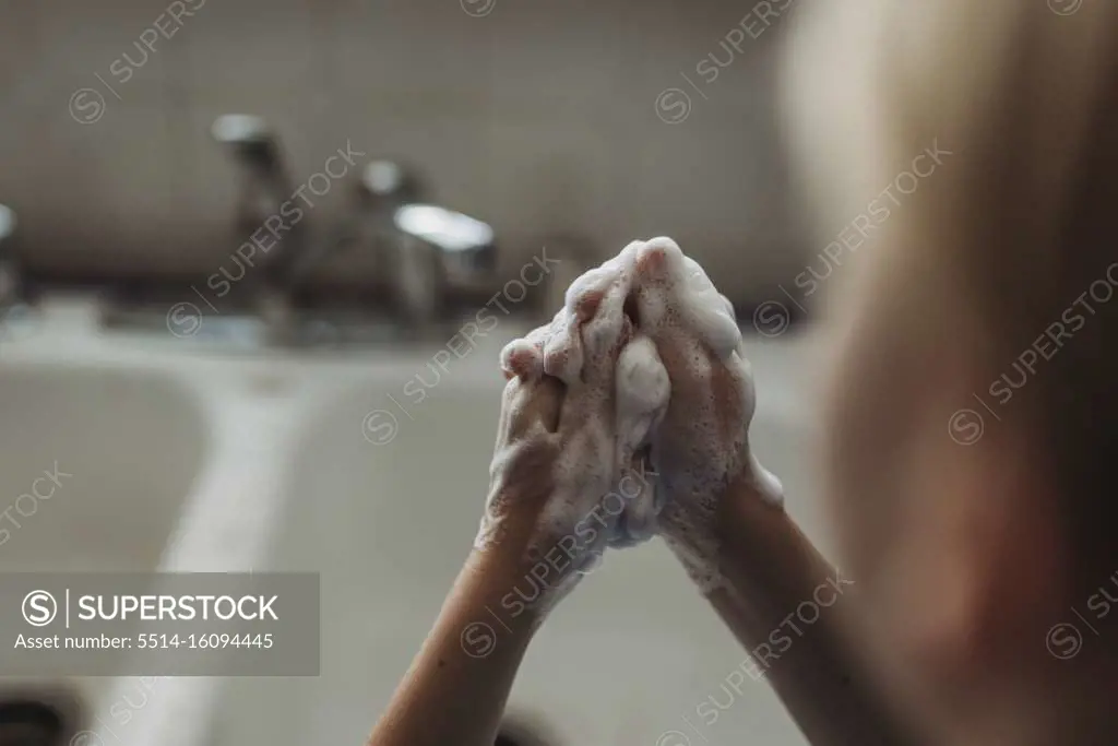 Close up of young hands being washed with soap