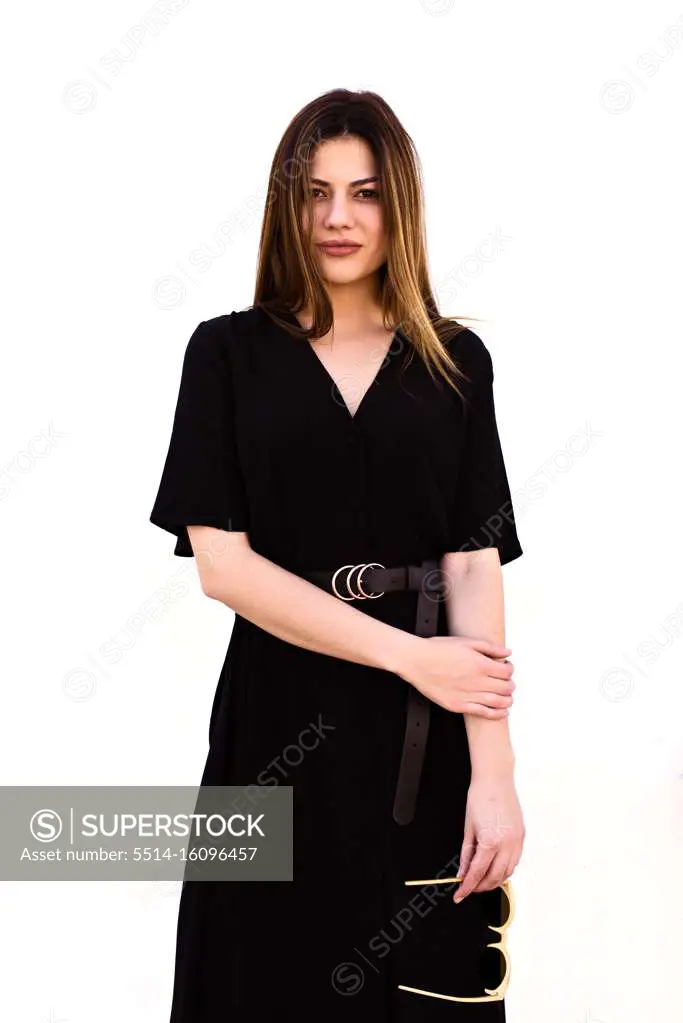 Attractive Caucasian woman poses in an elegant black dress in fr