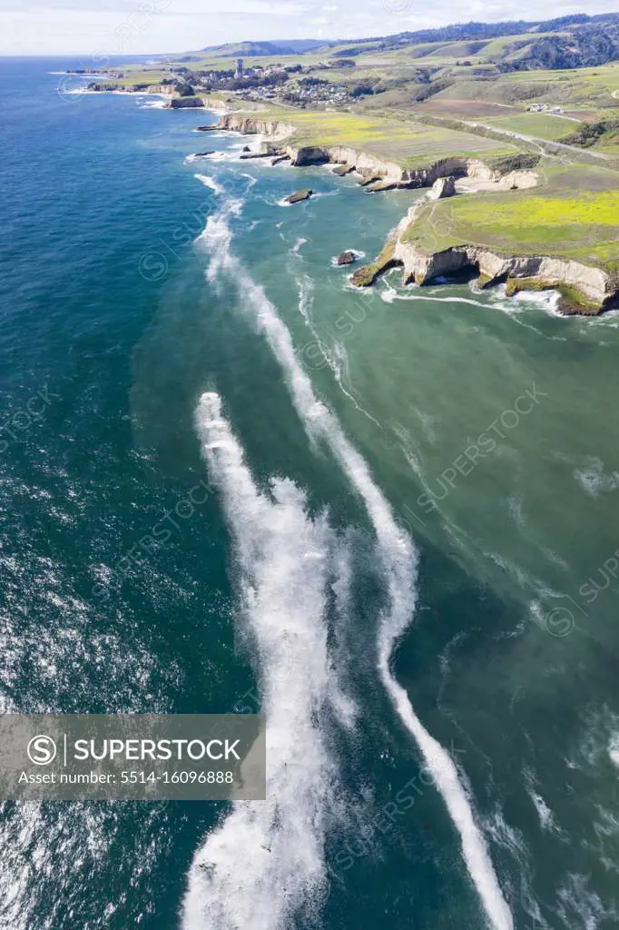 Rock formations and breaking waves in aerial over San Simeon CA