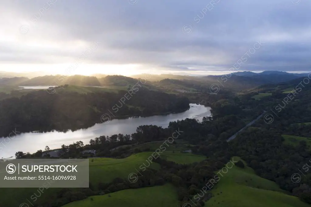 A Brilliant Sunrise Spreads Ray across Green Mountain Valley and Lake