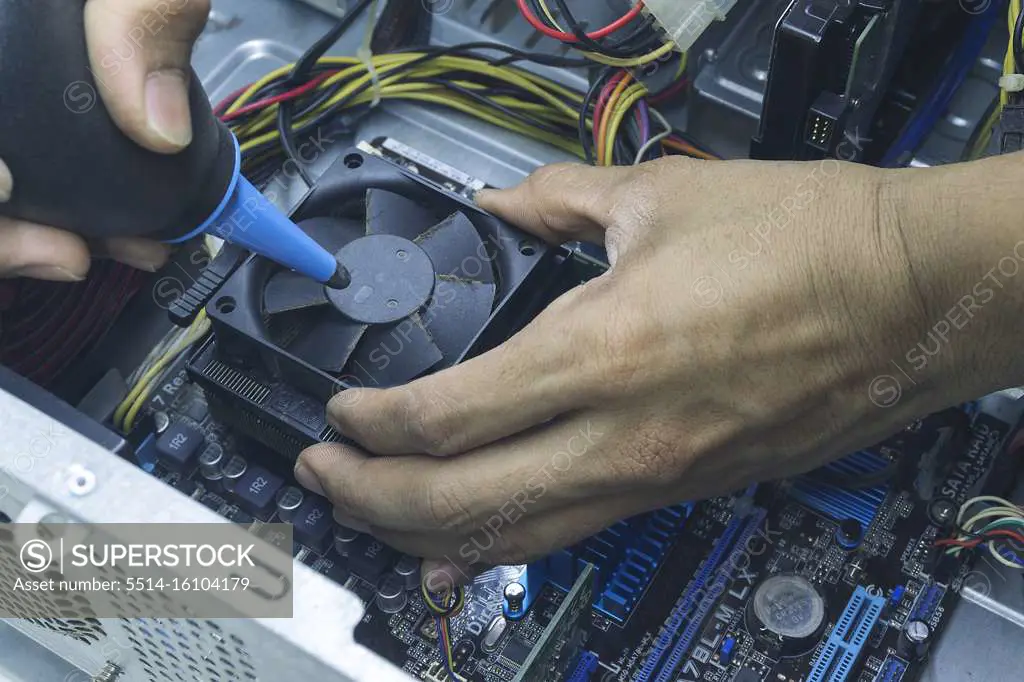 Men hands of Computer technician Cleaning the CPU fan of the computer.