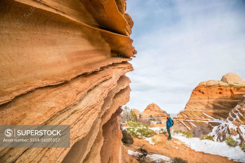 Sandstone lace rock and hiker for scale, Vermilion Cliffs