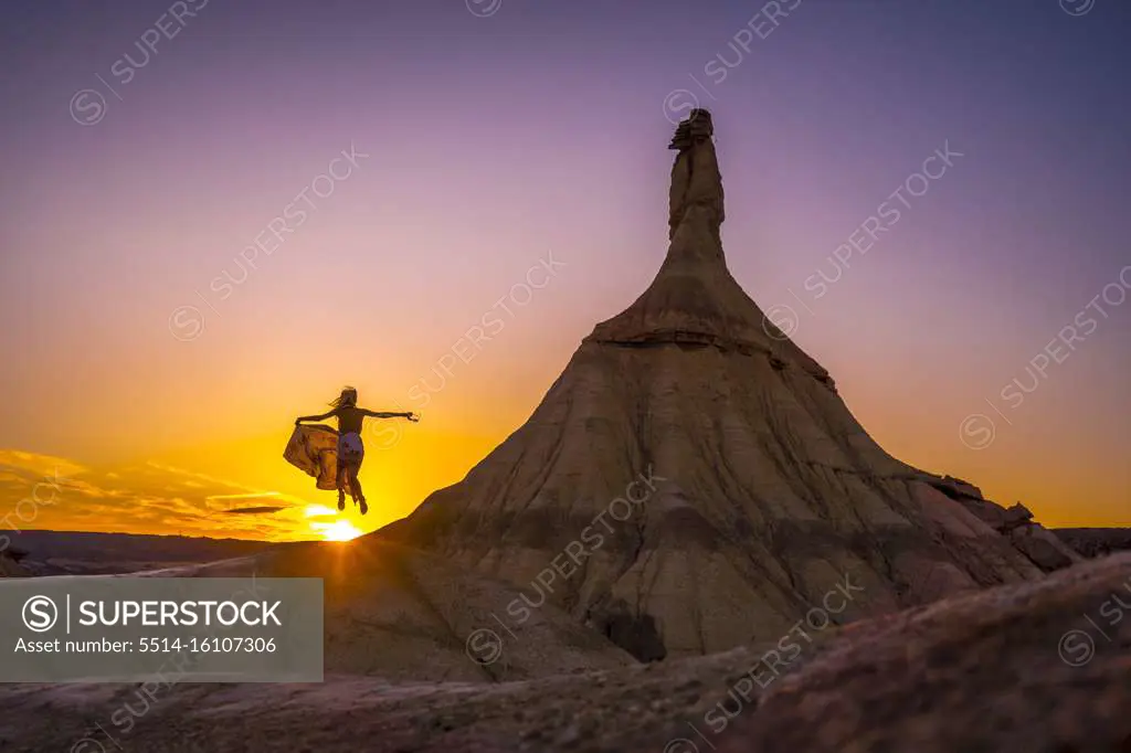 Silhouette of a blonde girl in a long dress in the Bardenas. Spain