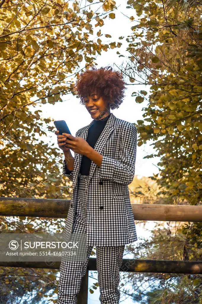 A Dominican girl with afro-red hair in an autumn session, sending a me