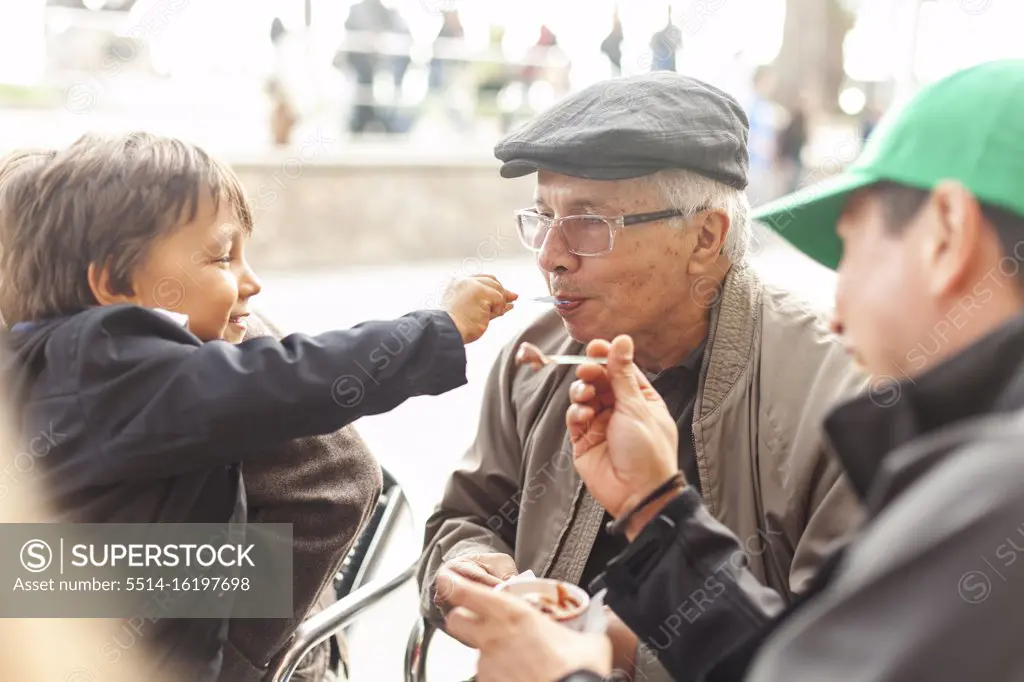 Grandson and grandfather sharing ice cream