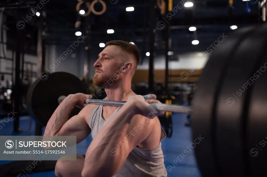 Focused athlete squatting with barbell