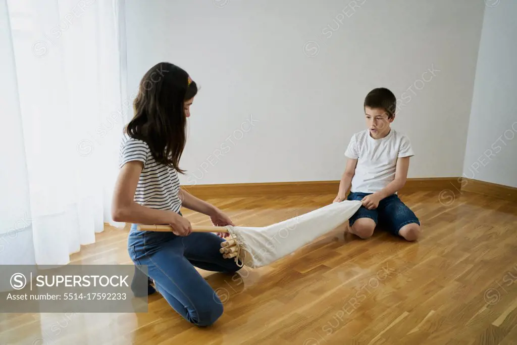 Children setting up a teepee tent inside their house. Childhood concept