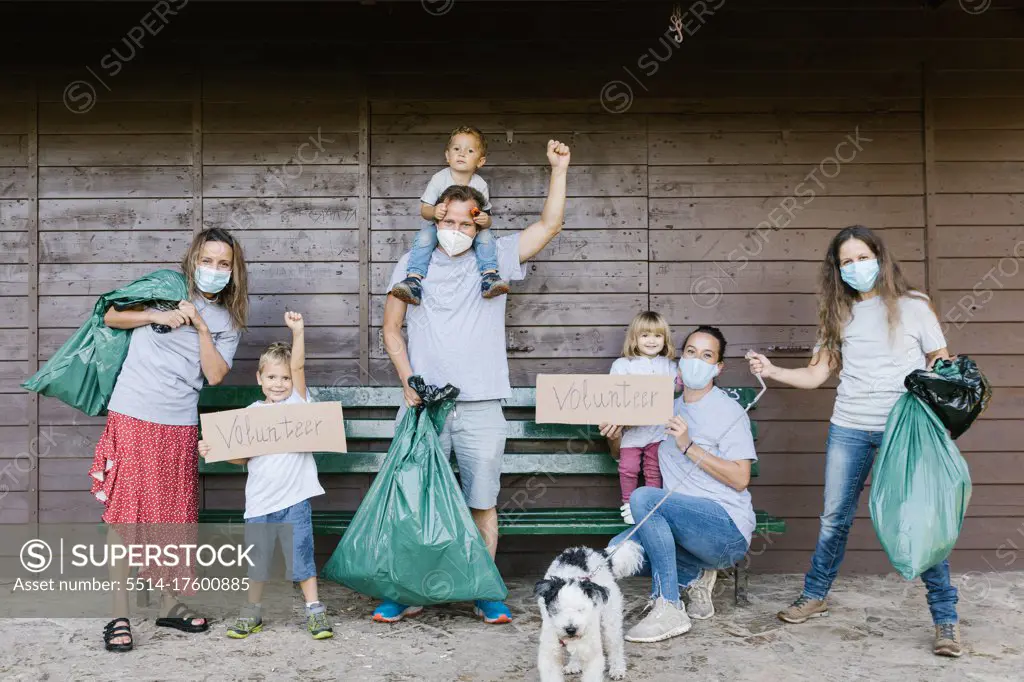 Group of volunteer families wearing medical masks and holding garbage