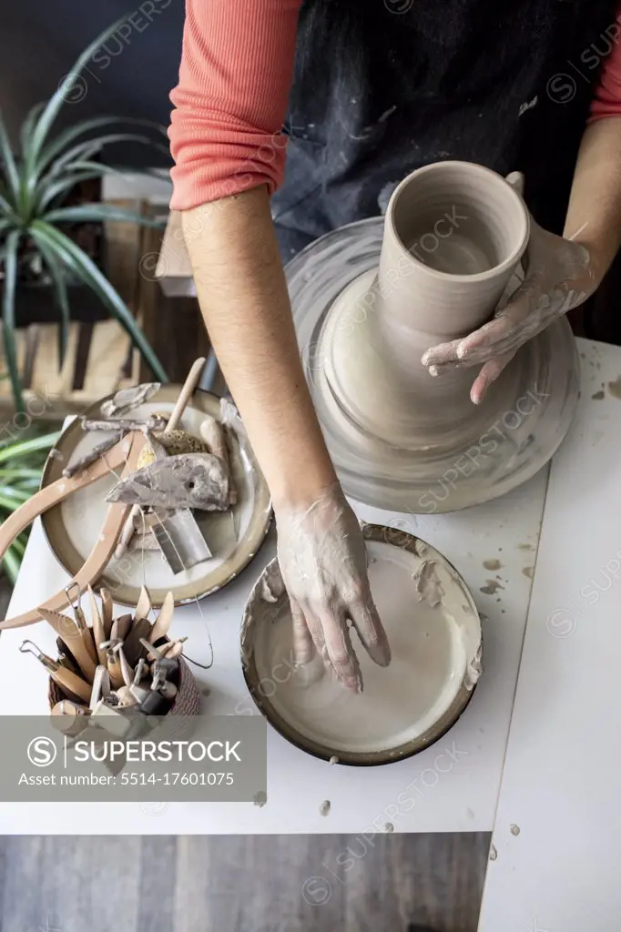 Hands making a ceramic pot at home studio