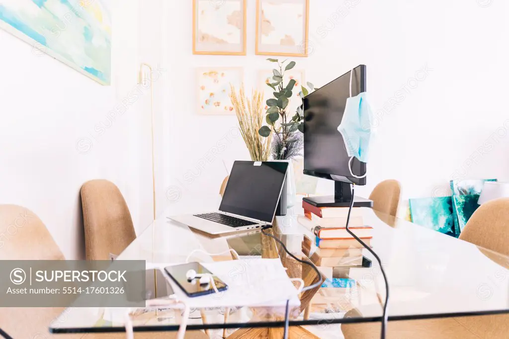 Modern home office with gadgets and medical mask
