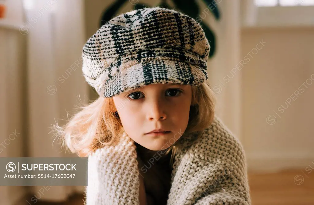 portrait of a young child with a hat on looking serious