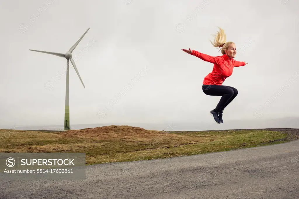 Female athlete leaping with outstretched arms