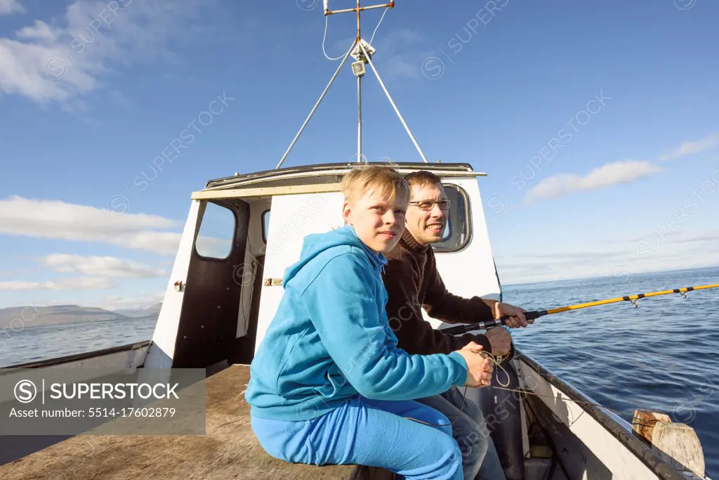 Father fishing with son on boat