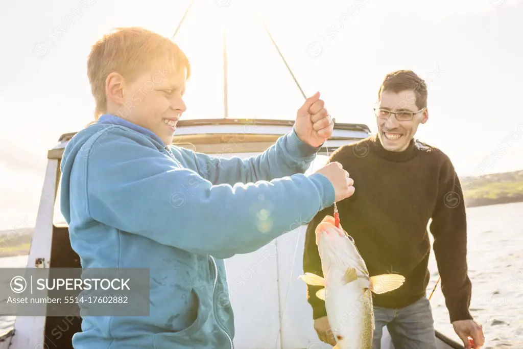 Father and son fishing on boat together
